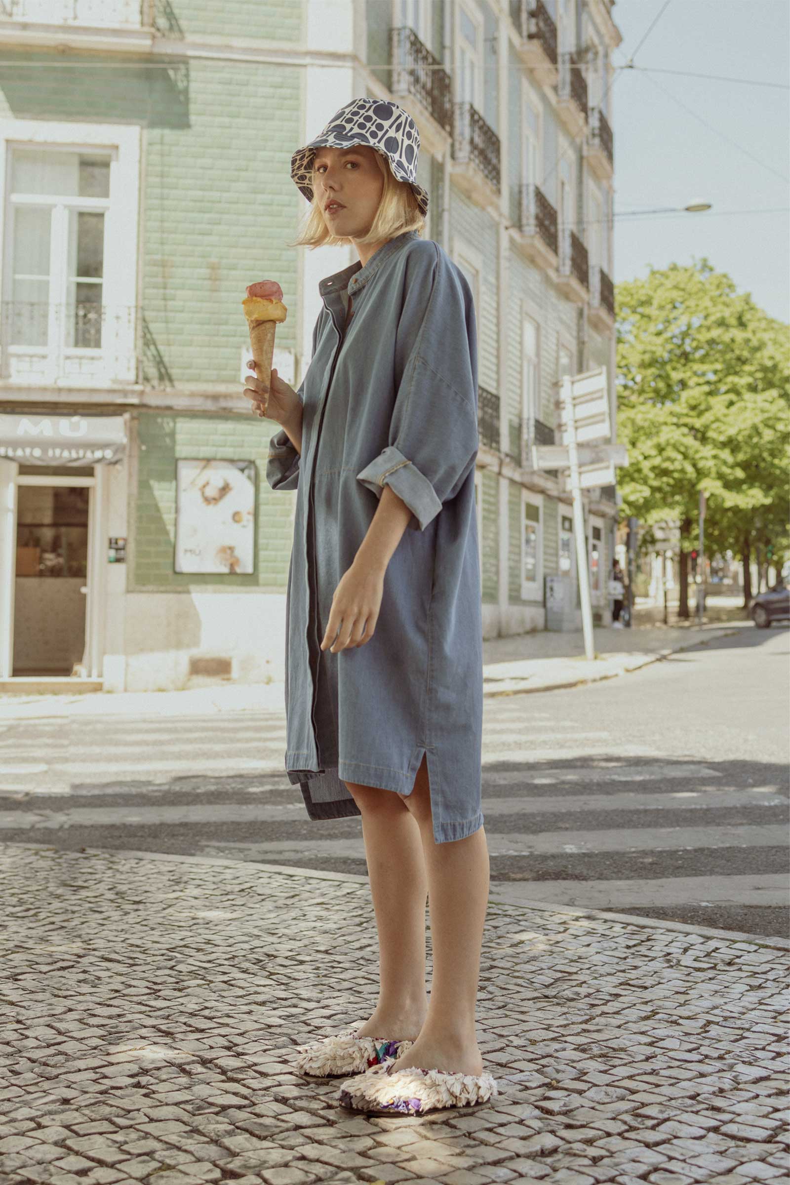 Model having ice cream and wearing a 10 to 10 denim shirt dress and hat