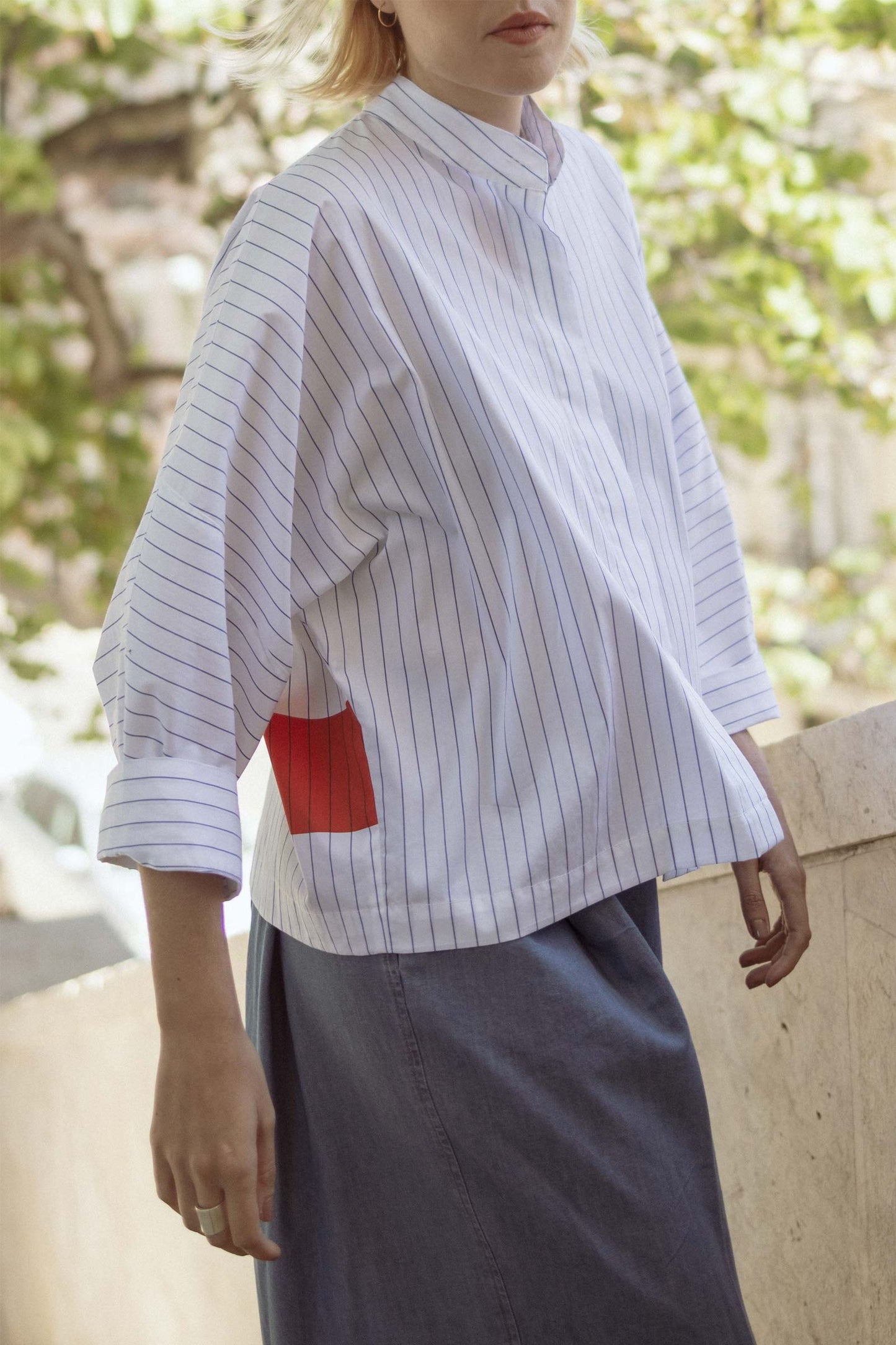 Model wearing 10 to 10 oversized striped white and blue shirt with coral rectangles pattern in the back