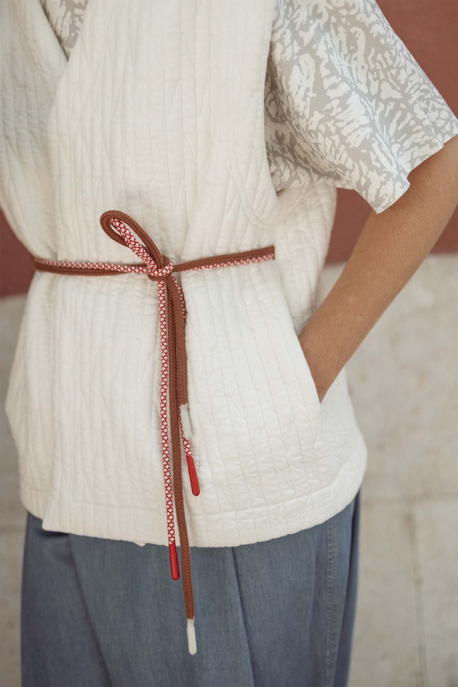 Model wearing 10 to 10 textured quilt vest 