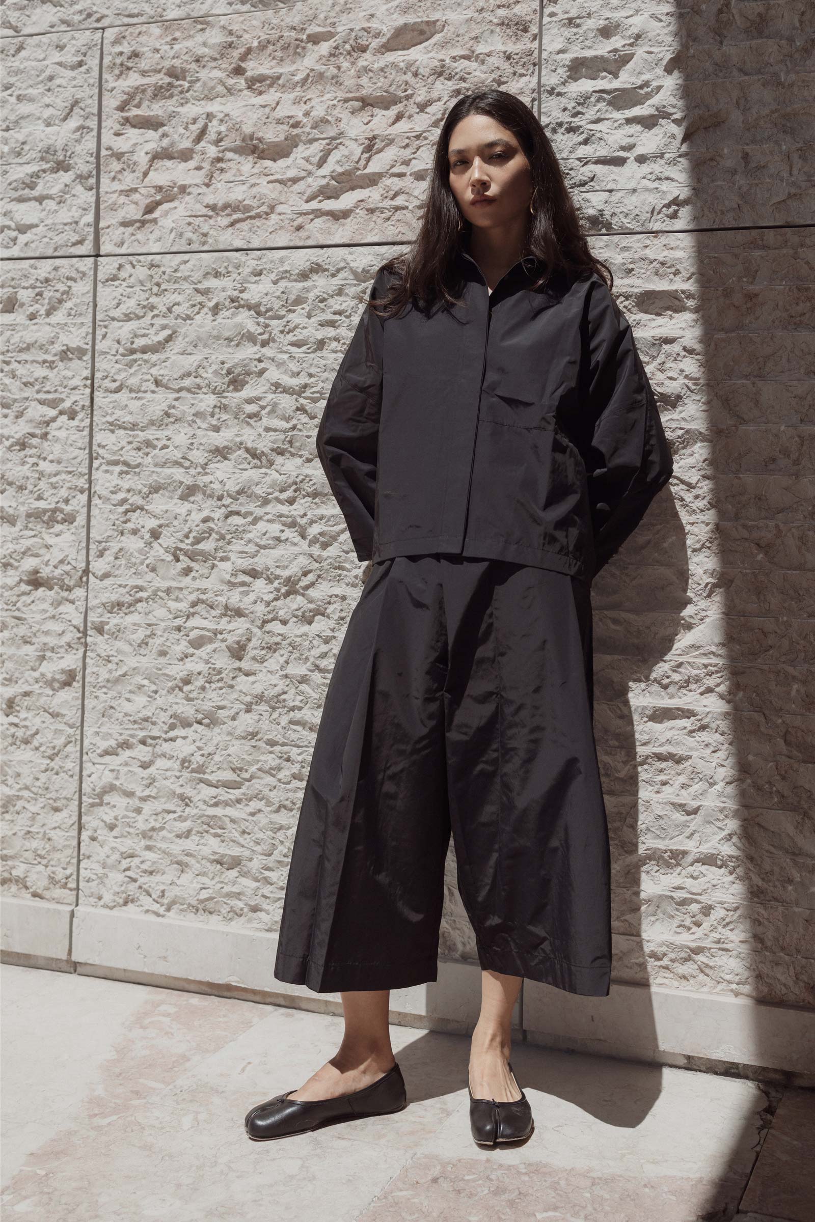 Model walking in 10 to 10 Black oversized trousers and shirt