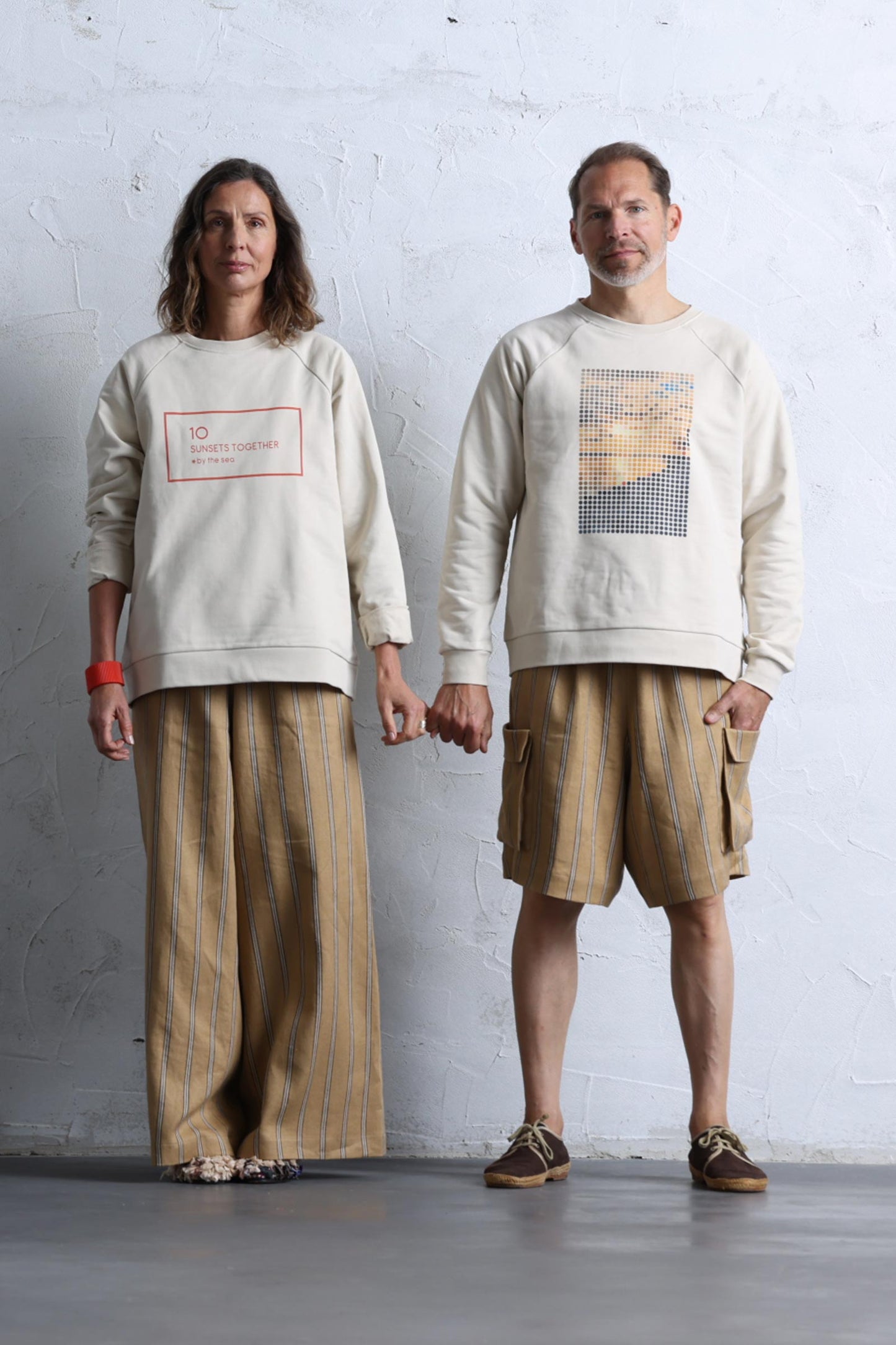 Couple wearing 10 to 10 Unisex sweatshirt with Dots print representing a sunset by the sea